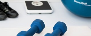 Therapiegeräte, wie Gymnastikball, Hanteln und eine Waage